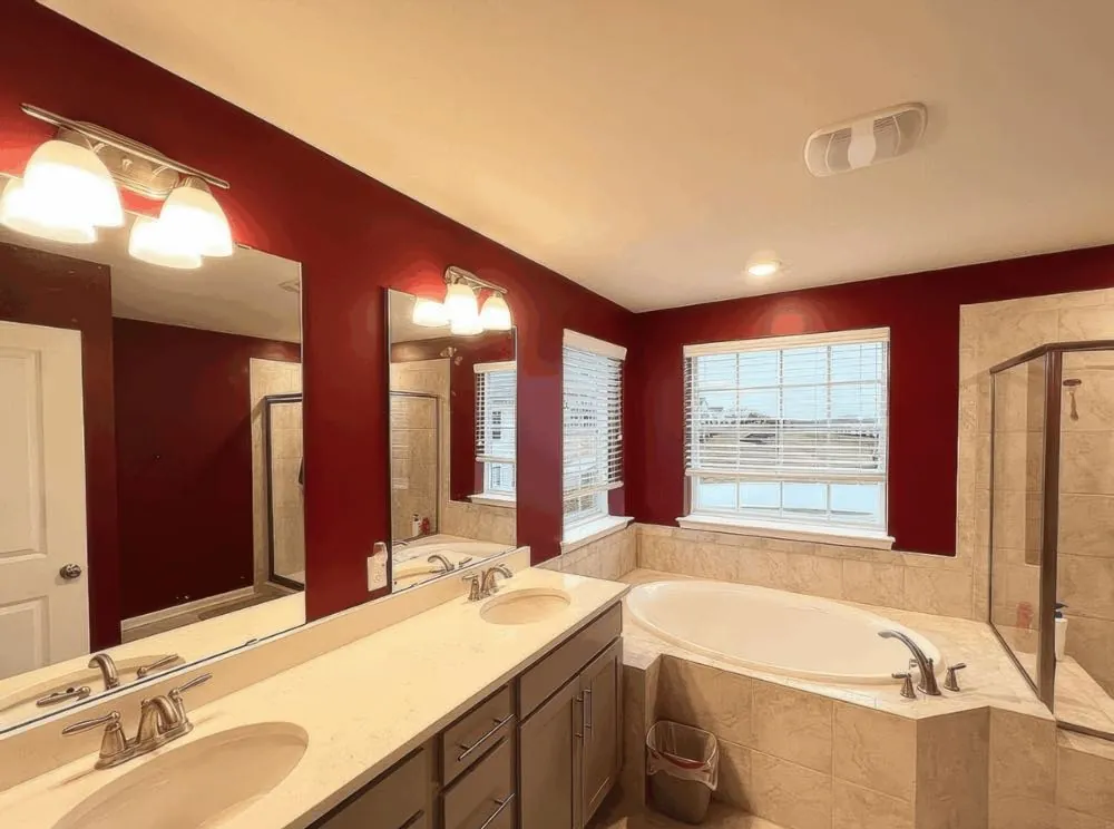 Bathroom repainted by Rise and Prime Painting in deep red with a cream ceiling and gray-brown painted vanity cabinets